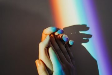 persons hands with rainbow colors
